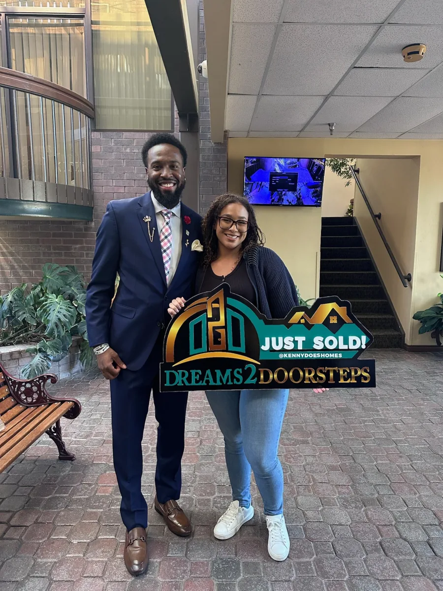 Two Dreams 2 Doorsteps clients celebrating a successful closing in a courtyard