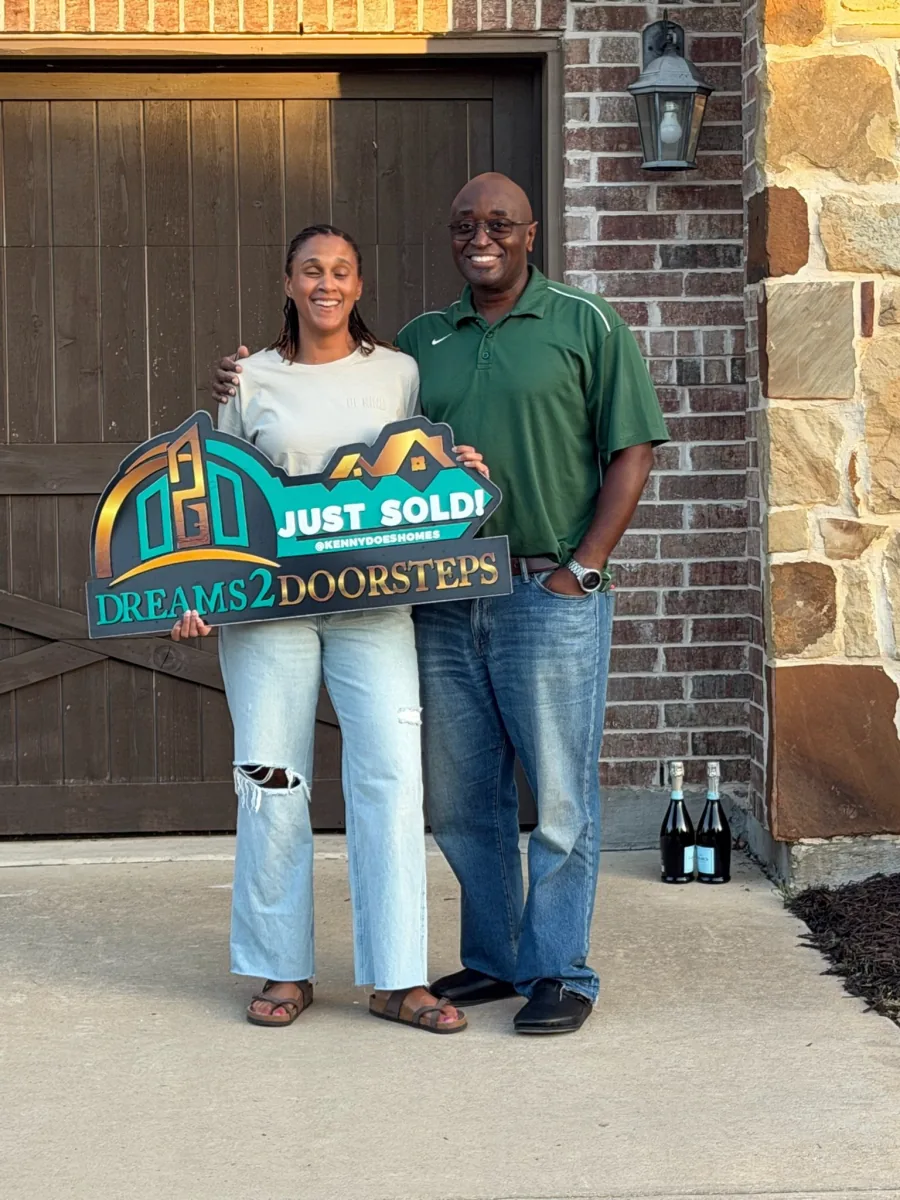 New homeowners celebrating at their front door with the Just Sold sign